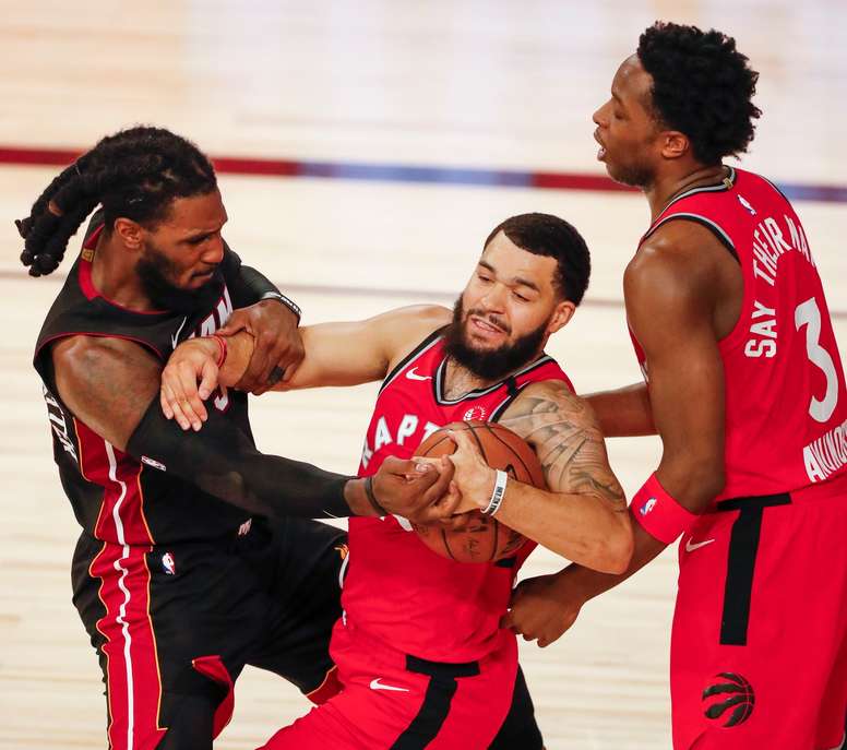 Jae Crowder (i) de los Heat de Miami en acción frente a Fred VanVleet (c) y OG Anunoby (d) de los Raptors de Toronto, en el ESPN Wide World of Sports Complex en Kissimmee, Florida (EE.UU.), hoy 3 de agosto de 2020. EFE/Erik S. Lesser
