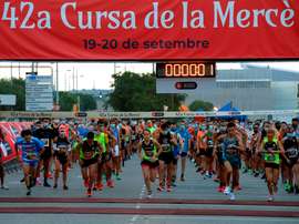 Varios corredores mantienen la distancia de seguridad al tomar la salida, que ha sido escalonada, en la primera serie de carreras de la primera jornada de la 42 edición de la Cursa de la Mercè. EFE/Toni Albir