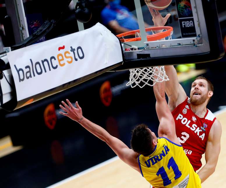 El jugador de la selección de Polonia Mihail Sokolowsky (d) trata de anotar ante la oposición del jugador de la selección de Rumanía Radu Virna, durante el partido clasificatorio para el Eurobasket de 2022 de este sábado en Valencia. EFE/Miguel Ángel Polo