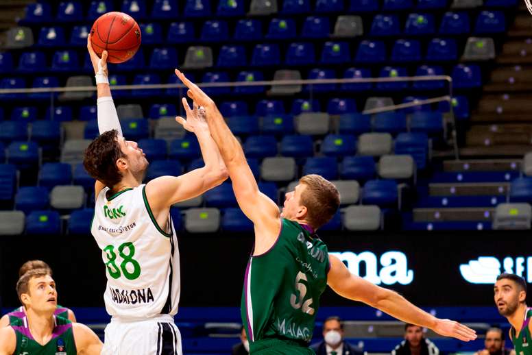 El pívot ucraniano del Unicaja, Volodymyr Gerun (d), defiende al pívot croata del Joventut Badalona, Ante Tomic (i), durante el primer partido del Top 16 de la Eurocopa, disputado en el Palacio de los Deportes José María Martín Carpena, en Málaga. EFE/Carlos Díaz