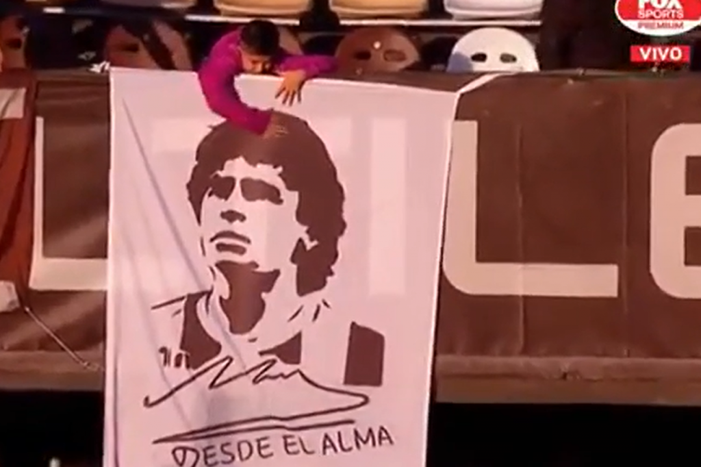 Pura emoción: un niño acarició una bandera con la cara de Maradona
