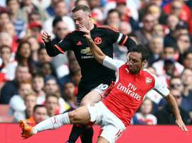 Cazorla y Rooney pelean por un balón en el encuentro entre el Arsenal y el United.