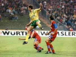 Sutton shoots with two Bayern Munich players looking on back in 1993.