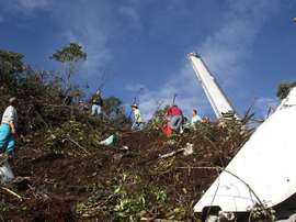 Des passants au milieu des décombres de l'avion accidenté.