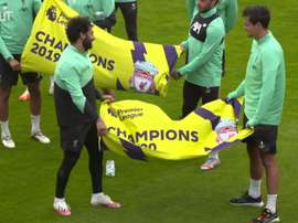 Elenco do Liverpool exibe bandeiras em alusão ao título inglês. DUGOUT