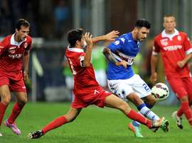 El futbolista de la Sampdoria, Roberto Soriano, salva la entrada de un jugador del Como, de Lega Pro, durante la pretemporada de 2014. Sampdoria