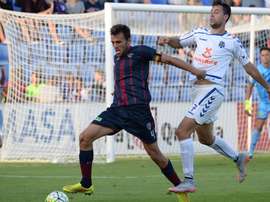 El futbolista del Huesca Carlos David, pugna por un balón con un jugador del Tenerife. Twitter