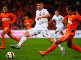 James Milner (L) of English Premier League side Liverpool fights for the ball with Shane Stefanutto of A-League side Brisbane Roar during a friendly at Suncorp Stadium in Brisbane on July 17, 2015.
