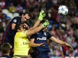 Júlio César, guardameta del Benfica, pugna por un balón aéreo con Godín y Saúl