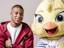 Kylian Mbappé, junto a la mascota del Mundial Femenino. FIFA