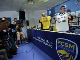 Li Wing-Sang (C), CEO of Hong-Kong based company Ledus, and financial director Chi Hung Chiu (R) show the new jerseys of Sochaux football club on July 6, 2015 during a press conference at the Auguste Bonal stadium in Montbeliard