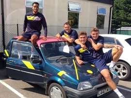 Varios jugadores del Oxford United posan con el coche comprado por el técnico. Instagram