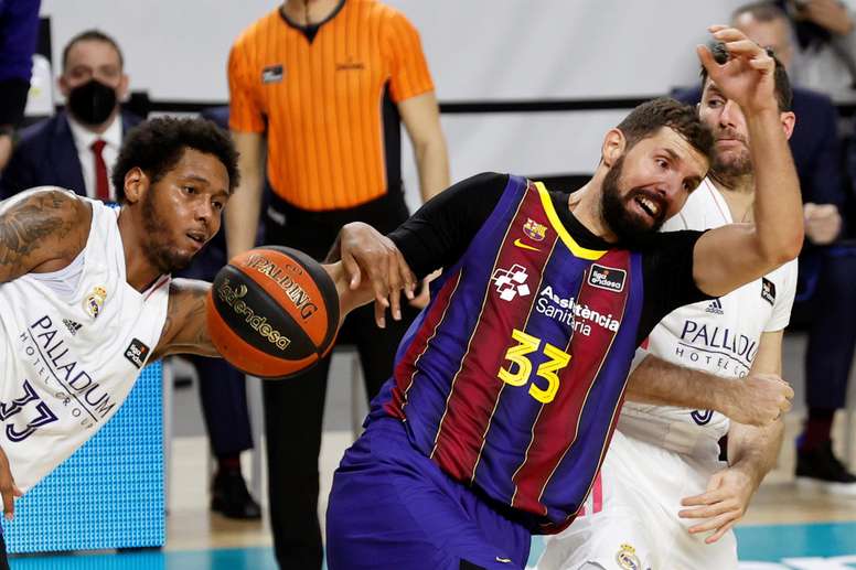 El ala pívot del Real Madrid Trey Thompkins (i) lucha con Nikola Mirotic, del Barça, durante el partido de Liga ACB en el WiZink Center, en Madrid. EFE/Chema Moya/Archivo