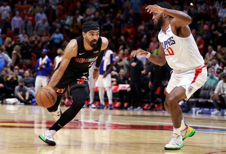 El escolta de los Miami Heat, Gabe Vincent (izquierda), pasa el balón por encima del delantero de Los Angeles Clippers, Justise Winslow (derecha) durante el partido de baloncesto de la NBA entre Miami Heat y Los Ángeles Clippers, hoy, en el FTX Arena de Miami, Florida (EE.UU.). EFE/ Rhona Wise PROHIBIDO SU USO POR SHUTTERSTOCK