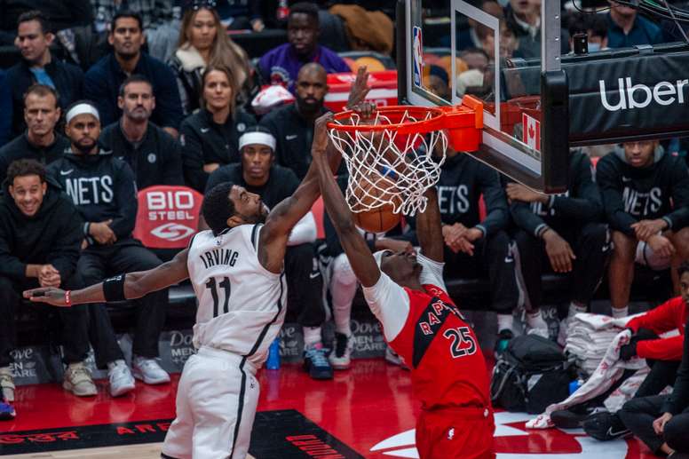 Chris Boucher (d) de los Toronto Raptors en acción hoy contra Kyrie Irving de los Brooklyn Nets, durante un juego de la NBA en el Scotiabank Arena de Toronto (Canadá). EFE/Eduardo Lima