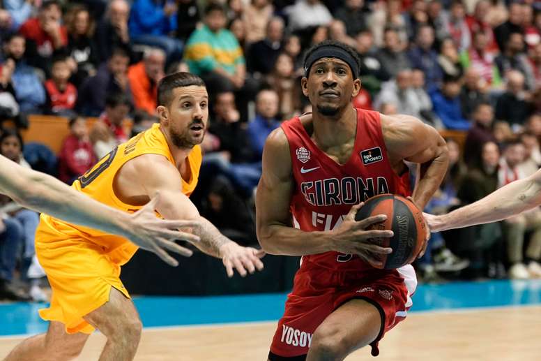 El alero estadounidense del Básquet Girona Kameron Taylor (d) penetra ante la defensa de Nicolás Laprovittola (i), base argentino del Barça, durante el encuentro de Liga Endesa entre el Básquet Girona y FC Barcelona en el Pabellón Municipal Gerona-Fontajau, en Gerona. EFE/David Borrat