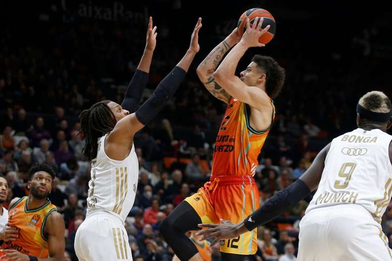 El escolta estadounidense del Valencia Basket Jonah Radebaugh intenta un lanzamiento ante el pívot estadounidense del Bayern de Munich Freddie Gillespie, durante el partido correspondiente a la jornada 22 de la Euroliga disputado en el pabellón de la Fuente de San Luis de Valencia. EFE/Miguel Ángel Polo